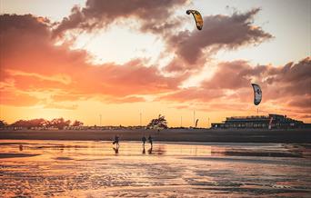 Kitesurfers on Littlehampton beach with a sunset
