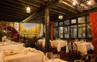 restaurant tables and wooden beamed room with lead glass windows