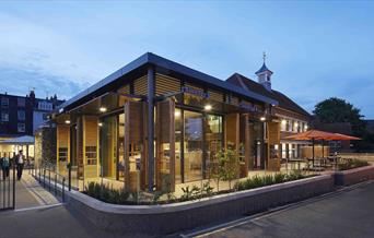 exterior photo of The Depot at dusk, with warm lights glowing from within