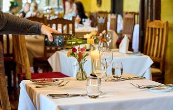stopham vineyard, wine bottle pouring into glass in restaurant