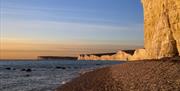 Birling Gap cliffs in background alongside setting sun and sea