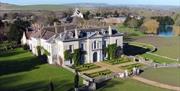 An aerial photo of Firle Place in Sussex, surrounded by grounds and lake