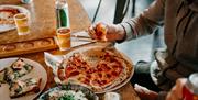 a table with plates of pizza and salad