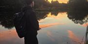 A young angler refining his skills whilst the sun sets.