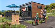 Family going cycling outside glamping pod