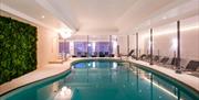 indoor swimming pool with lounger seating all around