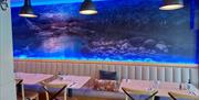 inside the restaurant showing tables and a large picture on the wall