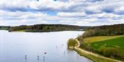 ardingly reservoir lake, with walking path around edge and paddle boarding on the water