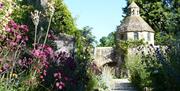 a pathway through the walled garden leading to a tower building