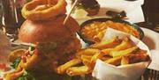 The Woods restaurant burger and chips, piled high including onion rings and beans.
