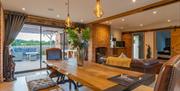 Lucky's Stable holiday cottage dining area, wooden table and view to decking outside.