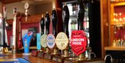 photo of the beer pumps at the wooden bar inside The Patridge, real ale and other beer taps