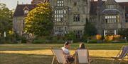 people sitting on deck chairs in front of main house