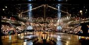 A view of Chichester Festival Theatre's auditorium seen from the stage. The stage thrusts out into the auditorium which is like an amphitheatre, with