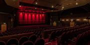 Internal view of the theatre seats and stage at Connaught theatre