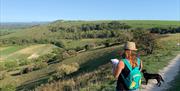 scenic view of the downs with a woman studying a map and a dog by her side