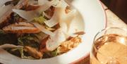 a bowl with a fresh salad and a glass of rose wine