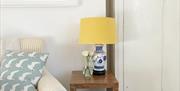 Yellow lamp positioned on top of a wooden side table in a living area