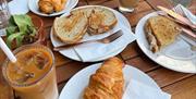 Table spread of Pastries, Toasties & Iced Coffee