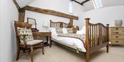 a wooden framed bed in a bright room with wooden beams