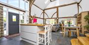 the main living space with some high seating and front door and lounge in the back ground
