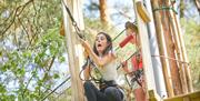 Woman stepping off the tarzan swing at Go Ape, screaming