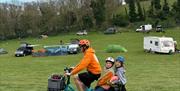 person ridiing with two children in the hamper at the back