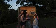 Images showing people chatting outside the sauna