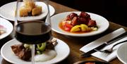 a close u of a plate of food with a glass of red wine beside it