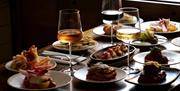 a table with wine and food next to a bright window