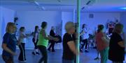 people doing a fitness class in a room with blue lighting