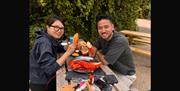 a couple enjoying seafood sitting outside at a bench table