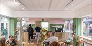 The inside of The Grub Club vegan cafe with people sitting enjoying their food and drinks