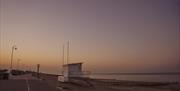 Littlehampton beach at sunset showing the promenade and the life guard hut