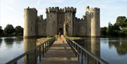 National Trust Bodiam Castle and moat, wooden bridge over the water leading to castle entrance