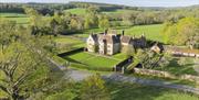 National Trust Bateman's house and garden, aerial view of the house, garden, adjacent buildings and surrounding countryside