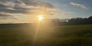 Sunset image of clouds over the wide open camping field at Newhouse Farm Camping