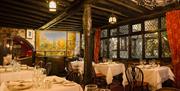 restaurant tables and wooden beamed room with lead glass windows