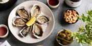 oysters and sharing bowls of with a bottle of wine