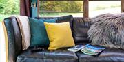 Cosy seating area inside the converted American school bus at Skoolie Stays