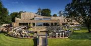 South Lodge spa exterior, wooden building with pool, terrace and loungers