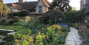 A garden of tulips and euphorbia looking towards the Great Hall