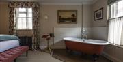 Bedroom at The Swan Inn with roll top bath