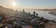 Sunset with group exploring the rocks and pools at low water.