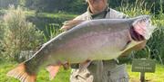 Chalk Farm trout fishery lakes, happy chap holding a massive trout.
