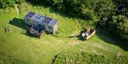 Drone view of the Eco-Cabin and wood-fired hot tub set in a secluded meadow in Sussex