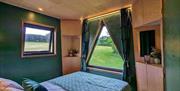 Bedroom inside the Eco-Cabin with large windows looking out over the Sussex landscape