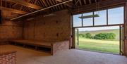 the camping barn with open doors to a view of the downs
