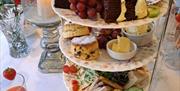 Traditional three-tier afternoon tea stand at Christina’s Tearoom featuring finger sandwiches, warm homemade scones with butter, cakes, brownies and f