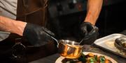 close up of chef dressing a plate of food